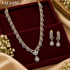 Gold plated crystal necklace set with matching earrings displayed on burgundy velvet